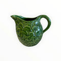 Brocca in ceramica con foglie a rilievo, altezza della brocca circa 17 cm. Presenta qualche piccola spaccatura nella ceramica, come visibile dalle fotografie.